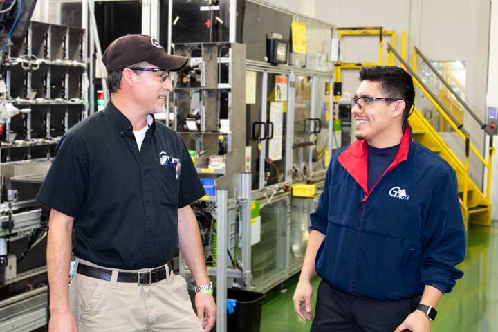 Two employees of Toyota Industries collaborate in the hallway of the factory.